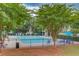 Community pool with lounge chairs, picnic tables, and lush landscaping surrounded by a fence at 2275 Black Pebble Cir, Buford, GA 30519