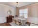 Well-lit dining area with decorative wainscoting, elegant chandelier, and view of outdoor window at 2275 Black Pebble Cir, Buford, GA 30519