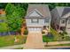 Aerial view of a charming two-story home with a well-manicured lawn, beautiful landscaping, and a two car garage at 2275 Black Pebble Cir, Buford, GA 30519