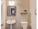 Cozy half bath with framed mirror, pedestal sink, and an elegantly decorated wall shelf at 2275 Black Pebble Cir, Buford, GA 30519
