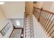 Carpeted staircase from above with wooden railings, iron spindles, and view of the home's entrance at 2275 Black Pebble Cir, Buford, GA 30519