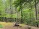 Landscaped backyard features a fire pit and fence surrounded by tall trees at 3420 Griffin Way, Cumming, GA 30040