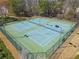 Aerial view shows two well-maintained outdoor tennis courts surrounded by trees at 3420 Griffin Way, Cumming, GA 30040