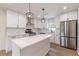 Bright and modern kitchen with a center island, stainless steel refrigerator, and stylish pendant lights at 525 Rosemont Dr, Decatur, GA 30032