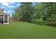 Large, well-maintained backyard with lush green grass, mature trees, and a view of the screened porch at 6240 Vista Crossing Way, Cumming, GA 30028