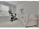 This versatile room features a stationary bike, a plush couch and soothing decor at 6240 Vista Crossing Way, Cumming, GA 30028