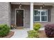 Charming front entrance with a dark wood door, sidelight window, and tasteful landscaping at 6240 Vista Crossing Way, Cumming, GA 30028