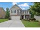 Charming two-story home featuring a brick facade, well-manicured lawn, and attached two-car garage at 6240 Vista Crossing Way, Cumming, GA 30028