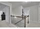 Well lit upstairs hallway featuring a wood railing and multiple bedrooms at 6240 Vista Crossing Way, Cumming, GA 30028
