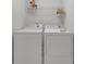 A bright laundry room features a wire rack and modern washer and dryer at 6240 Vista Crossing Way, Cumming, GA 30028