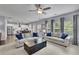 Bright living room featuring gray sofas, large windows, and an open view to the kitchen at 6240 Vista Crossing Way, Cumming, GA 30028