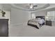 Bright main bedroom with tray ceilings, neutral walls, ceiling fan, and several windows at 6240 Vista Crossing Way, Cumming, GA 30028