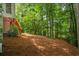 Backyard of home with mature trees, a wood deck, and landscaping at 1444 Merrifield Ln, Marietta, GA 30062