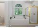 Bathroom featuring a large tub under a window, and a shower with gold trim at 1444 Merrifield Ln, Marietta, GA 30062