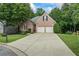 Charming brick home featuring a well-manicured lawn, mature trees and a two-car garage at 1444 Merrifield Ln, Marietta, GA 30062