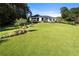 Expansive lawn leads to a luxury home with a pool and outdoor living spaces, surrounded by trees at 3085 Lake Park Dr, Jonesboro, GA 30236