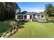A lush backyard features a manicured lawn, leading to a stunning pool area and outdoor living space at 3085 Lake Park Dr, Jonesboro, GA 30236
