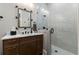 Bright bathroom with a wooden vanity, marble countertop, glass shower with white tiled walls, and modern fixtures at 3085 Lake Park Dr, Jonesboro, GA 30236