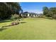 Expansive rear yard with landscaped gardens and a modern home set against a lush wooded backdrop at 3085 Lake Park Dr, Jonesboro, GA 30236