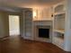 Living room featuring built-in shelving, fireplace, and hardwood floors at 3794 W Hayward Ct, Tucker, GA 30084