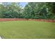 A spacious, well-maintained backyard featuring lush green grass and a privacy fence surrounded by mature trees at 5928 Edenfield Nw Dr, Acworth, GA 30101
