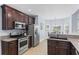 Modern kitchen featuring stainless steel appliances, granite counters, dark wood cabinets, and a breakfast nook at 5928 Edenfield Nw Dr, Acworth, GA 30101