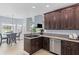 Kitchen features dark wood cabinets, granite countertops, stainless steel appliances, and dining area at 5928 Edenfield Nw Dr, Acworth, GA 30101