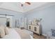 Stylish main bedroom featuring a tray ceiling, hardwood floors, and a decorative dresser at 5928 Edenfield Nw Dr, Acworth, GA 30101