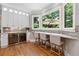 Stylish bar area with ample seating, a wine fridge, and a bright view of the backyard at 2510 Wood Creek Ct, Dacula, GA 30019