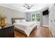 Cozy bedroom featuring hardwood floors, a comfortable bed, and a large window with natural light at 2510 Wood Creek Ct, Dacula, GA 30019