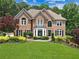 Charming two-story brick home with manicured lawn, mature landscaping, and classic architectural details at 2510 Wood Creek Ct, Dacula, GA 30019