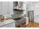 Gourmet kitchen featuring a stainless steel range hood, granite countertops, and top-of-the-line appliances at 2510 Wood Creek Ct, Dacula, GA 30019