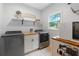 Bright laundry room with modern washer and dryer, butcher block countertops, and open shelving at 2510 Wood Creek Ct, Dacula, GA 30019