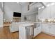 An open concept living room and kitchen with an island and stainless steel sink and appliances at 2510 Wood Creek Ct, Dacula, GA 30019