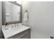Stylish powder room featuring a gray vanity, a quartz countertop, and a framed mirror at 2510 Wood Creek Ct, Dacula, GA 30019