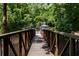 Wooden walking bridge surrounded by greenery and leading towards a gate at 3235 Roswell Ne Rd # 514, Atlanta, GA 30305