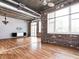 Bright living room featuring hardwood floors, exposed brick, ceiling fan, and modern lighting at 3235 Roswell Ne Rd # 514, Atlanta, GA 30305