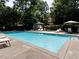 Community pool surrounded by lounge chairs and lush greenery in the background at 3235 Roswell Ne Rd # 514, Atlanta, GA 30305
