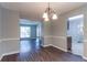 View of the dining room, entryway, and living room with neutral walls and wood flooring at 3470 River Mill Ln, Ellenwood, GA 30294