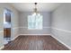 Dining room features a chandelier, a large window, and wood laminate flooring at 3470 River Mill Ln, Ellenwood, GA 30294