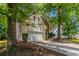Well-maintained home with an attached two-car garage and a mature tree in the front yard at 3470 River Mill Ln, Ellenwood, GA 30294
