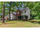 Inviting two-story home with a brick facade, lush lawn, and a mature tree at 3470 River Mill Ln, Ellenwood, GA 30294