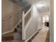 Inviting hallway featuring a carpeted staircase and decorative tile flooring at 3470 River Mill Ln, Ellenwood, GA 30294