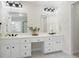 Bathroom featuring dual vanity sinks, a large mirror, and modern lighting fixtures at 4711 Oakleigh Manor Dr, Powder Springs, GA 30127