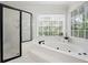 Bathroom featuring a soaking tub with jets, a large window and a separate shower at 4711 Oakleigh Manor Dr, Powder Springs, GA 30127