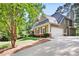 A beautiful home showing an attached garage, driveway and lush, mature landscaping at 4711 Oakleigh Manor Dr, Powder Springs, GA 30127