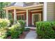 Inviting brick front porch with manicured landscaping and covered entryway to the home at 4711 Oakleigh Manor Dr, Powder Springs, GA 30127