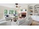 Bright living room with fireplace, built-in shelves, and large windows overlooking the outdoors at 4711 Oakleigh Manor Dr, Powder Springs, GA 30127