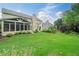 Expansive backyard featuring lush green grass, screened in porch, and manicured landscaping at 8045 Depford Way, Cumming, GA 30041