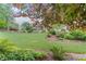 Serene backyard with lush lawn, mature trees, ornamental shrubs, and decorative stones at 8045 Depford Way, Cumming, GA 30041
